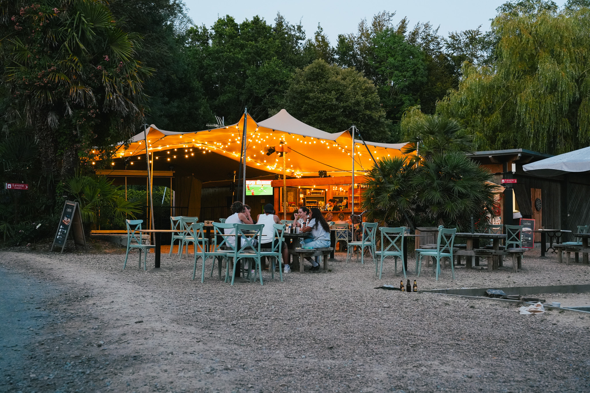 Tente stretch éclairée au crépuscule au-dessus d'une terrasse