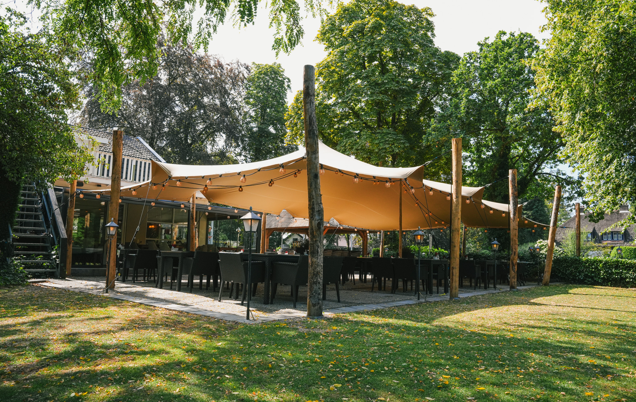 Terrasse couverte par une toile tendue vue depuis le jardin