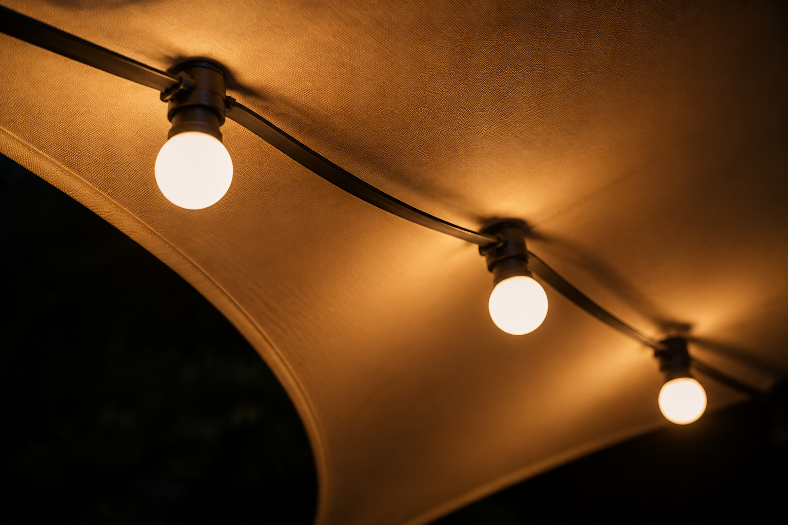 Guirlande d'ampoules tendue sous la toile, la nuit
