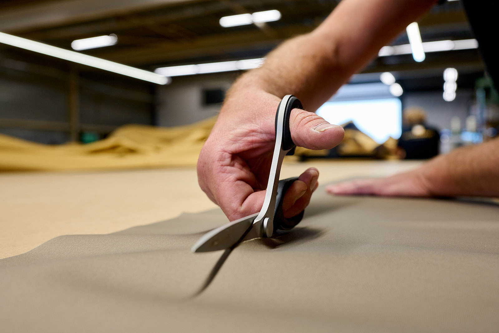 Coupe d'une toile sur une table de traçage dans un atelier partenaire