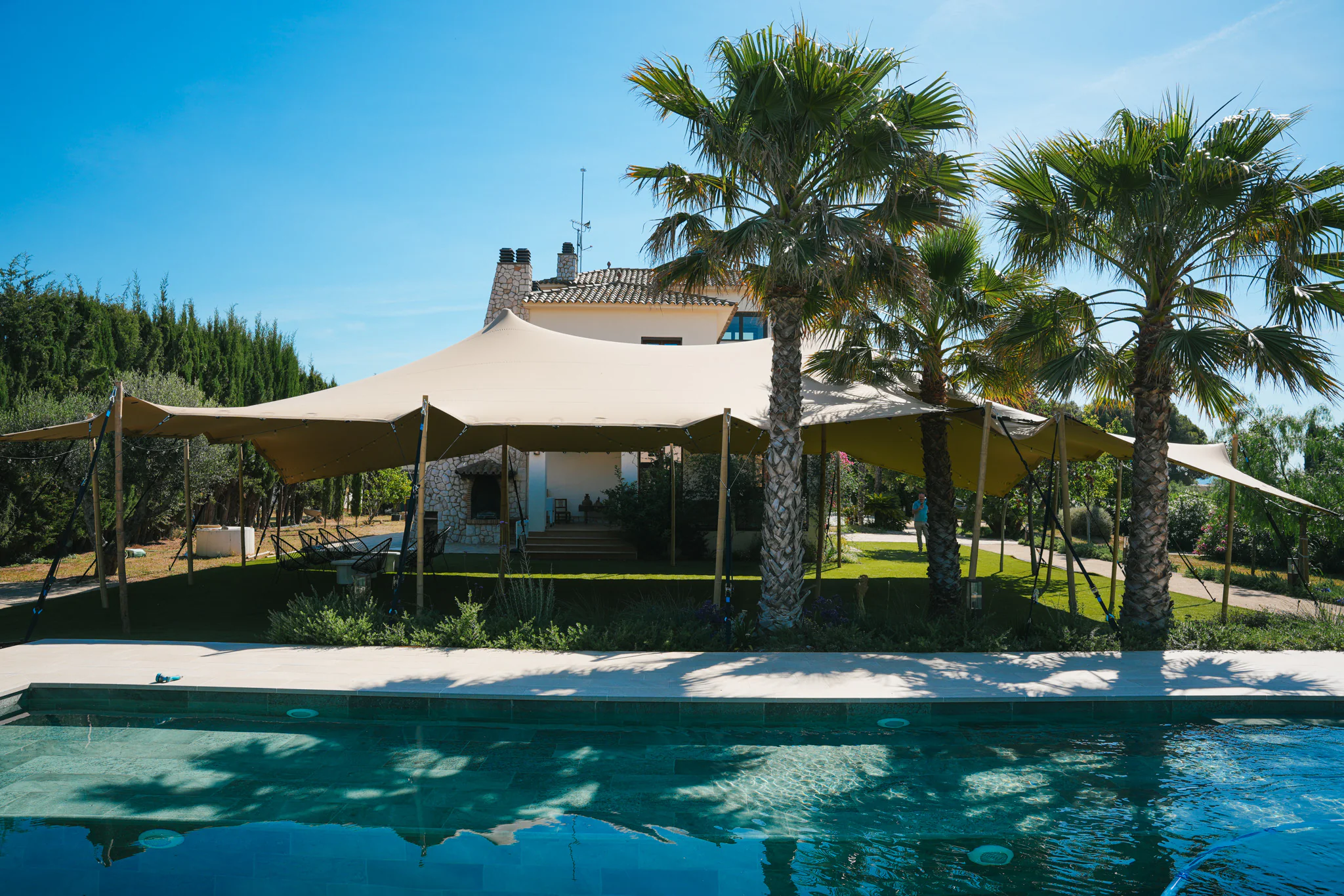 Tente stretch sable installée au bord d’une piscine